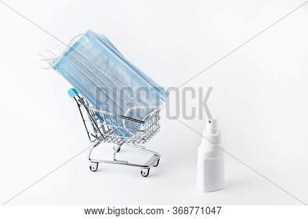 Medical Masks For Face And Spray For Disinfection In A Shopping Basket.