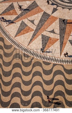 Top Down View Of Handmade Portuguese Tiles Pavement And Compass Rose With People Walking On It. Lisb