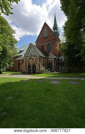 Part Of The Luebeck Cathedral With Narthex And Ridge Turret, View From The Idyllic Churchyard With  