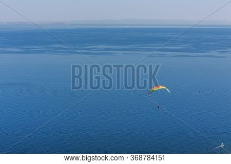 Paragliding Over A Dreamy Blue Sea On A Clear Summer Day