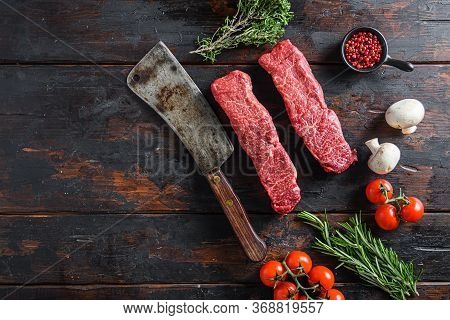 Raw Denver Machete Steak On A Meat Cleaver. Black Background. Top View Copyspace