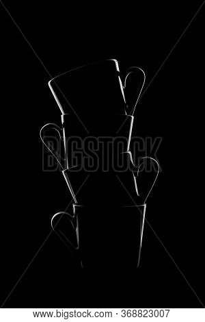 Silhouettes Of Small Coffee Cups On A Black Background. Beautiful Shape