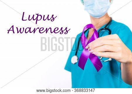 Female Doctor In Blue Uniform With Purple Awareness Of Ribbon In Hand For Lupus Awareness