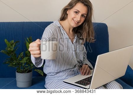 Woman Working On Laptop At Home Office While Drinling Coffee. Web Conection