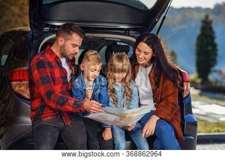 Close Up Of Joyful Pleasant Family Which Gethering On Their Vacation With Teen Children And Using Ro