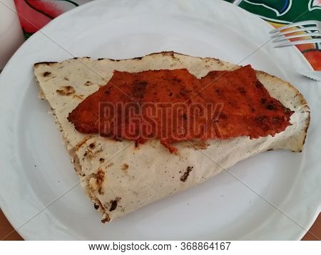 Traditional Oaxacan Dish Called Tlayuda With Enchilada Meat On A White Plate