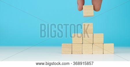 Hand Arranging Wood Block Stacking As Step Stair On Wooden Table. Business Concept For Growth Succes