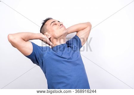 Relaxed Man Leaning Back With His Hands On The Back Of His Neck.