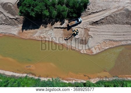 Environmental conservation issue. Machinery mining river, causing siltation and pollution 