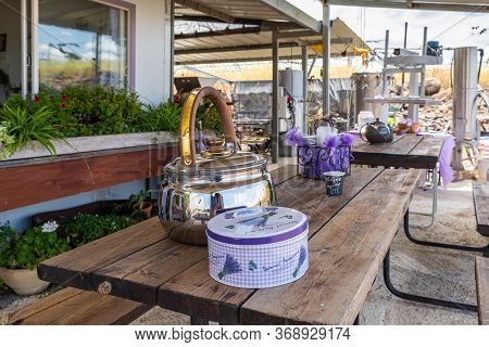 Kanaf, Israel, May 29, 2020 : A Courtyard Decorated In Purple, A Teapot With Lavender Tea And A Box 