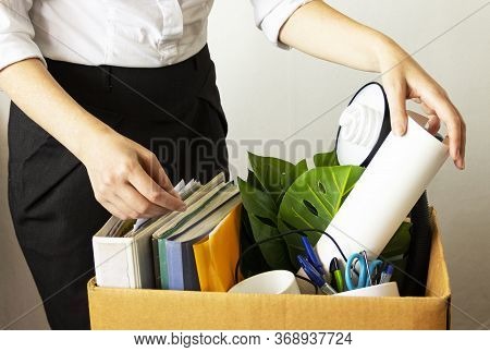 Lose Job Concept. Hand Holds Box Of Fired Worker. In A Box They Lay Documents, Folders, A Flower, St