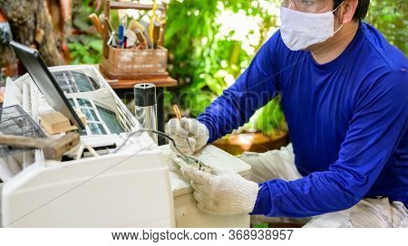 Asian Man Online Learning And Repair Air Conditioner At Home. New Normal Life After Covid-19. Lock D