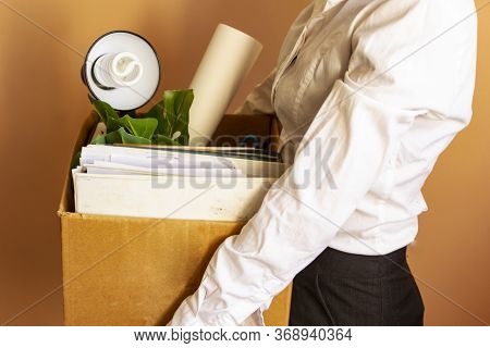 Lose Job Concept. Hand Holds Box Of Fired Worker. In A Box They Lay Documents, Folders, A Flower, St