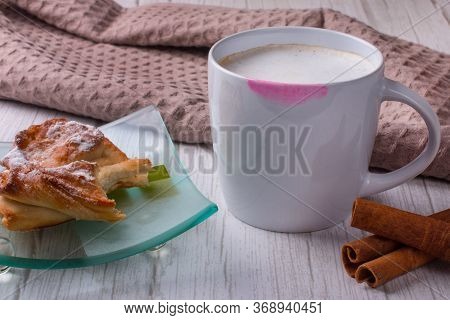 A Cup Of Coffee With A Lipstick Print On It. A Bitten-off Loaf On A Plate.