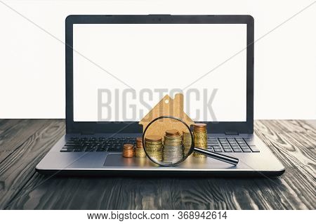 Concept Of The Sale And Rental Of Housing, Mortgage, Loan. Lap Top With Blank Screen And Heap Of Eur