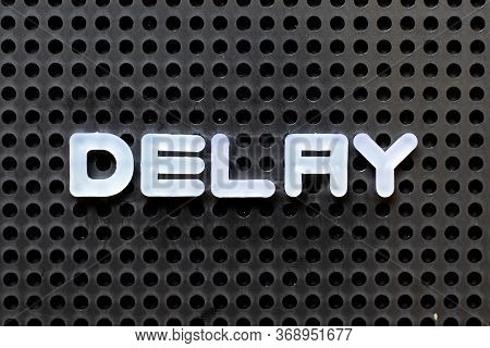 White Color Alphabet With Word Delay On Black Pegboard Background