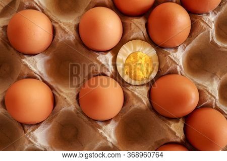 Eggs In Paper Tray. One Soft-boiled. View From Top. Boiled Halve