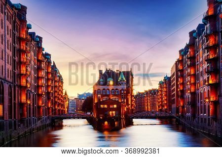The Warehouse District Speicherstadt During Twilight Sunset In Hamburg, Germany. Illuminated Warehou