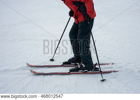A Man On Alpine Skis Dressed In Red Ski Jacket Skiing Down The Ski Slope.  Winter. Extreme Sport And