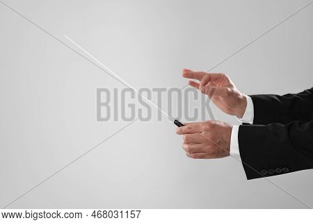 Professional Conductor With Baton On Light Grey Background, Closeup. Space For Text