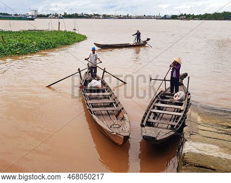 Mekong, September 2022: Wooden Boats On The Mekong River. Vietnamese Boatmen In Murky Waters Of The 