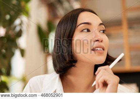 Close Up Portrait Of Stylish Young Brunette Woman, Sitting With Graphic Pen And Smiling, Relaxing In