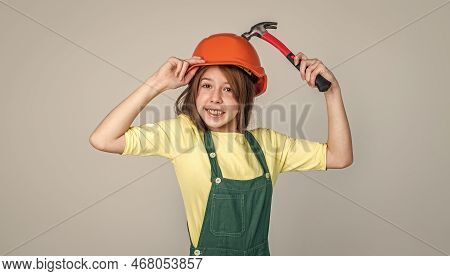 Examining. Renovation And Repair. Using Working Tool. Teen Girl In Helmet And Boilersuit With Hammer