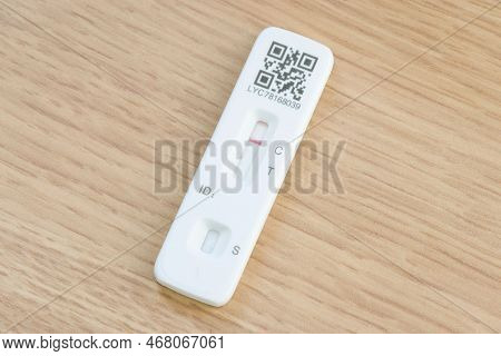 United Kingdom - March 26, 2022. Lft Testing. Covid 19 Lateral Flow Test Strip On A Wooden Desk. Red
