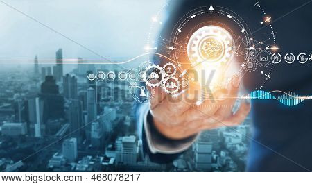 Businessman Holding Light Bulb With Gears And Cogs Inside, Symbolic Of Creativity Innovative Solutio