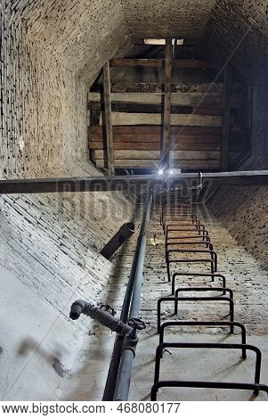 The Interior Of An Old, Historic, Brick Water Tower . The Photo Shows Octagonal Brick Walls, Old Wat