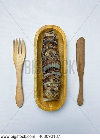 Boiled Taro Served On Oval Wooden Plate Fork On White Background.