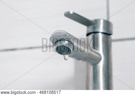Water Dripping From The Faucet In The Bathroom. Water Faucet Close-up. Saving Water