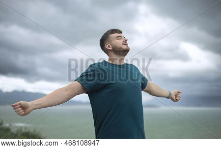 Happy Handsome Free Guy, Young Calm Relaxed Carefree Man Traveler With Open Raised Hands Enjoy Sea, 