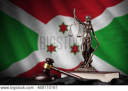 Burundi Flag With Statue Of Lady Justice, Constitution And Judge Hammer On Black Drapery. Concept Of