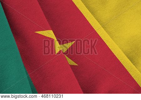 Cameroon Flag With Big Folds Waving Close Up Under The Studio Light Indoors. The Official Symbols An
