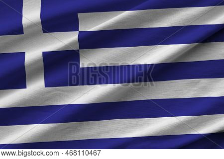 Greece Flag With Big Folds Waving Close Up Under The Studio Light Indoors. The Official Symbols And 
