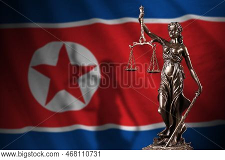 North Korea Flag With Statue Of Lady Justice And Judicial Scales In Dark Room. Concept Of Judgement 