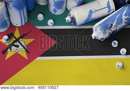 Mozambique Flag And Few Used Aerosol Spray Cans For Graffiti Painting. Street Art Culture Concept, V