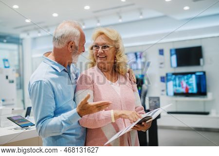 Seniors shopping appliences and gadgets in tech store.