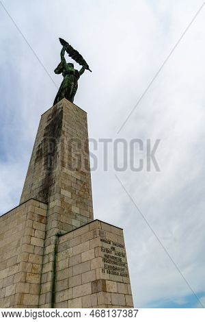 The Historic Liberty Statue Upon Gellert Hill In Front Of A Cloudy Sky In Budapest, Hungary