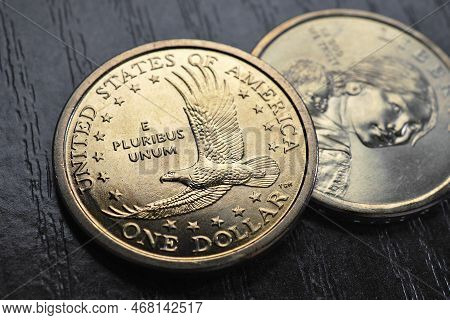 American Coins Close-up Lie On Dark Surface Of Table. Soaring Eagle Sacagawea Dollar Coin. Us Econom