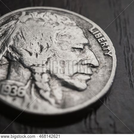 Us Nickel Lies On A Dark Table Surface. Coin 5 Cents Close-up. Buffalo Nickel. News About Usa Econom