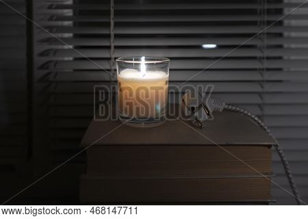 A Disconnected Electric Plug Lies In A Dark Empty Room Near The Window By The Light Of A Candle (clo
