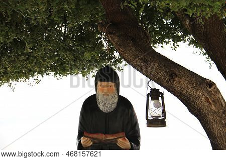 A Statue Of The Lebanese Saint Mar Charbel Reading A Book.