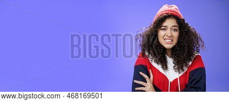 Woman With Curly Hair In Winter Beanie Feeling Uncomfortable And Discomfort Clenching Teeth And Frow