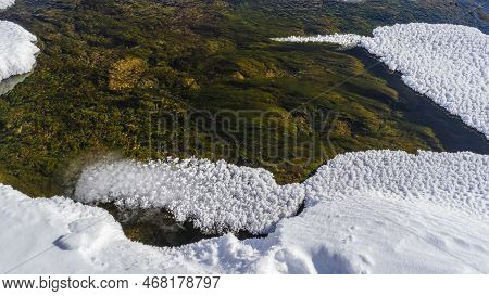 Thawed Stream In Early Spring. Close-up. Algae On The Bottom Are Visible Through The Clear Water. Fl