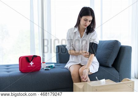 Woman Measuring Blood Pressure By Using Digital Sphygmomanometer At Home. Woman Using Medical Device