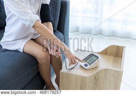 Woman Measuring Blood Pressure By Using Digital Sphygmomanometer At Home. Woman Using Medical Device