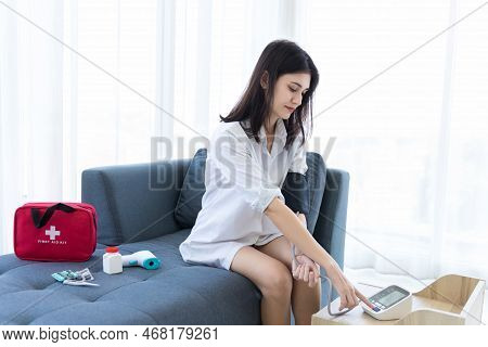 Woman Measuring Blood Pressure By Using Digital Sphygmomanometer At Home. Woman Using Medical Device