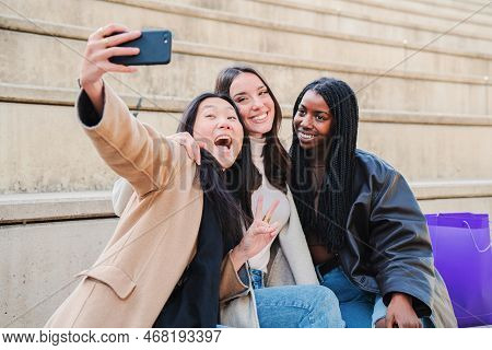 Group Of Young Woman Having Fun Doing A Selfie With Smartphone. Three Multiracial Happy Girls Amilin